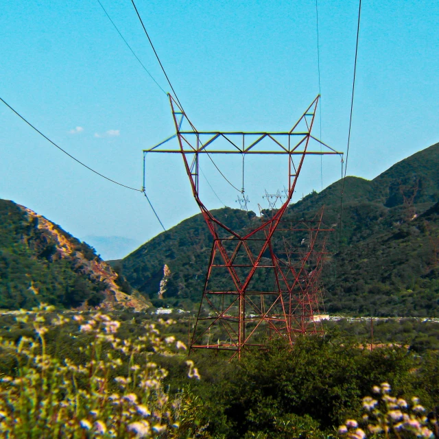 there is a tower in the field near hills