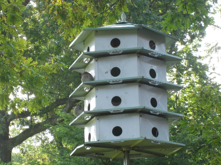 a tall bird house is sitting on top of a post