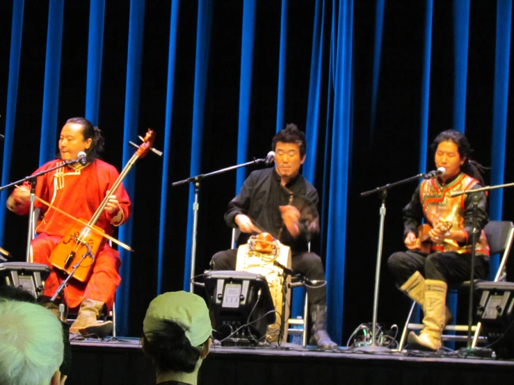 a band of indian musicians sit on stage