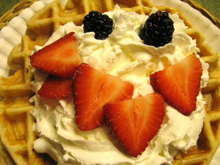 a waffle with whipped cream and strawberries on top