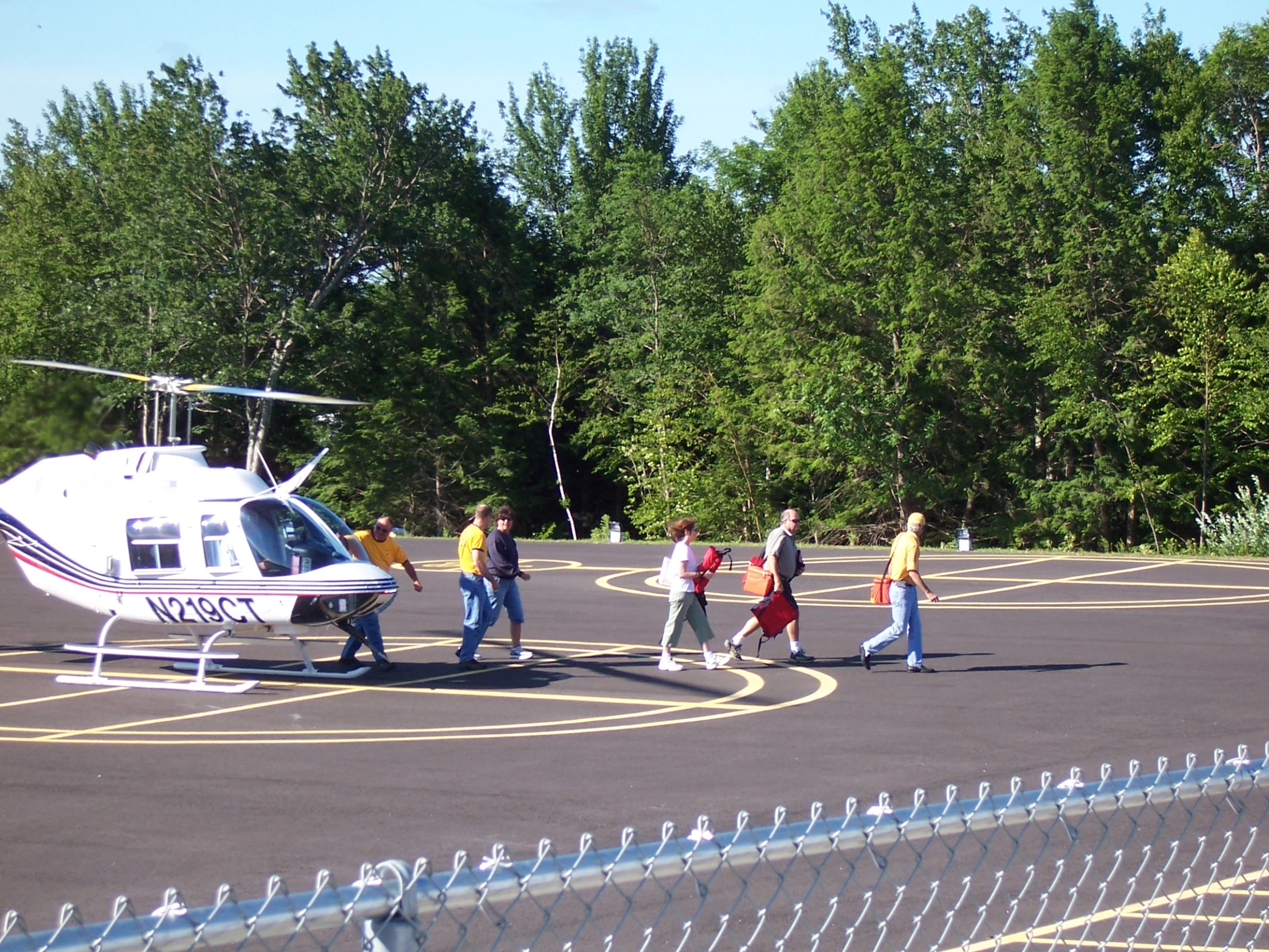 a helicopter with people walking by it on the pavement