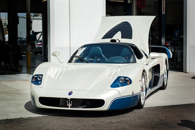 the white and blue car is parked in front of a building