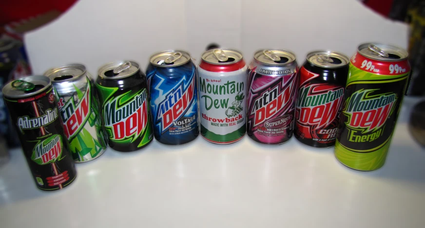 several different types of soft drinks on a white counter top