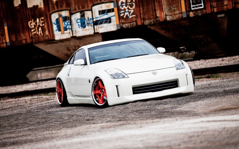 a white sports car in front of a train