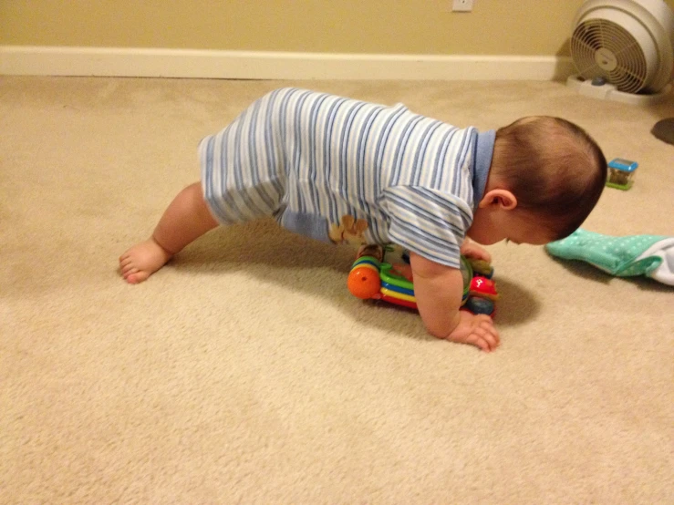 a small baby plays with a toy car on the floor