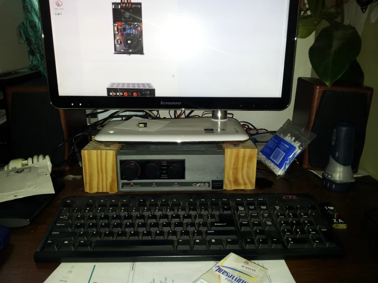 a computer monitor, keyboard and speakers sitting on a desk