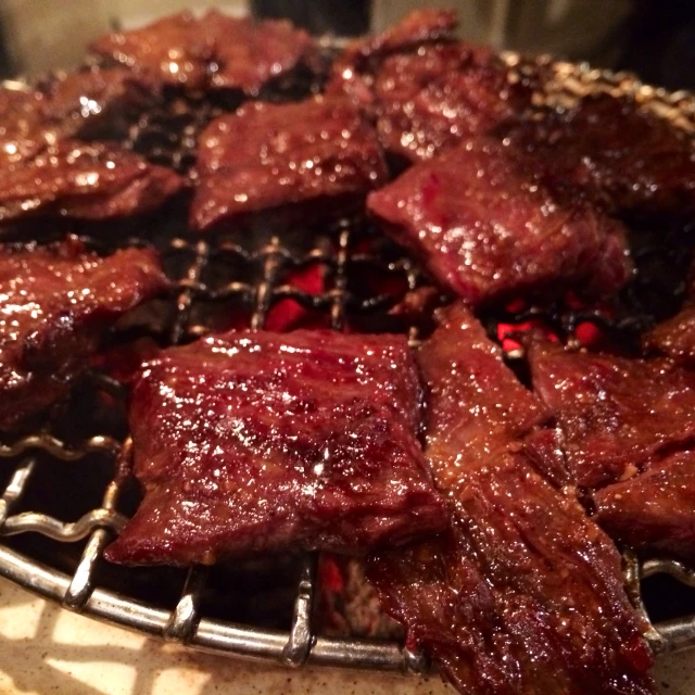 barbecue ribs are on a grill covered with sauce