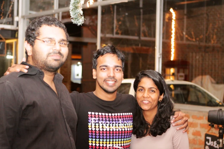 two men and a woman smiling for the camera