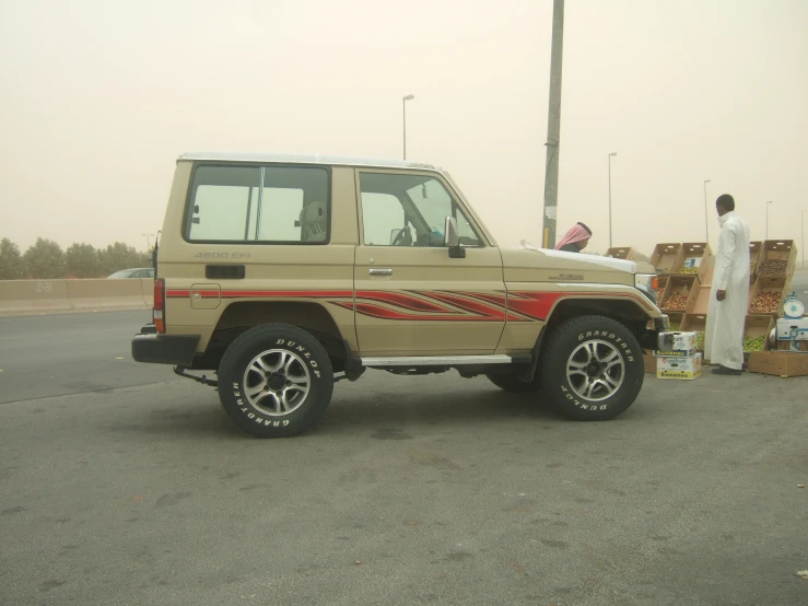 a tan pickup truck parked next to a man