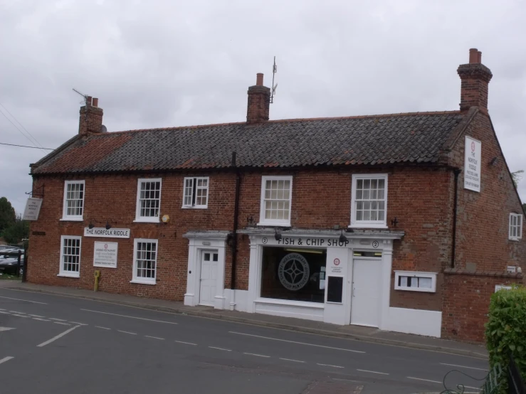 a red brick building with three stories sitting on a corner