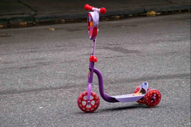 a small child's tricycle sitting on the street