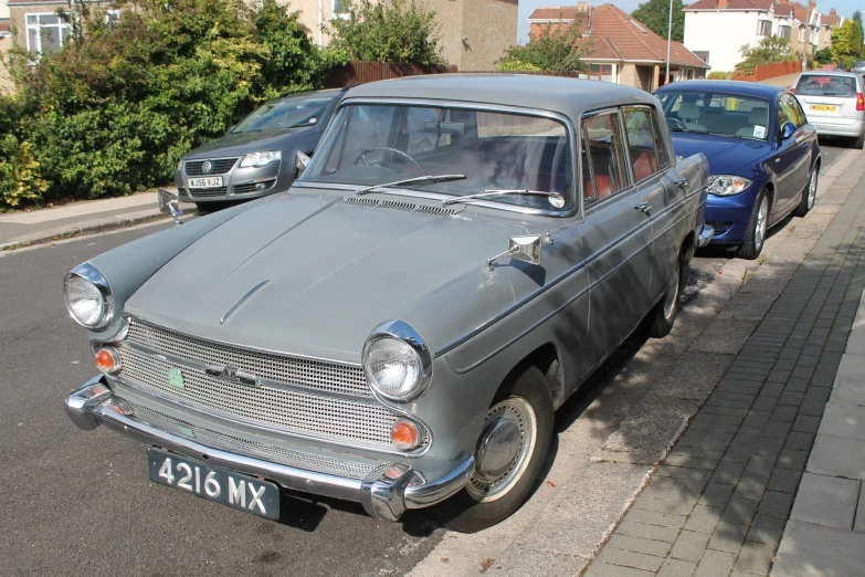 an old car sitting on the side of a road next to other cars