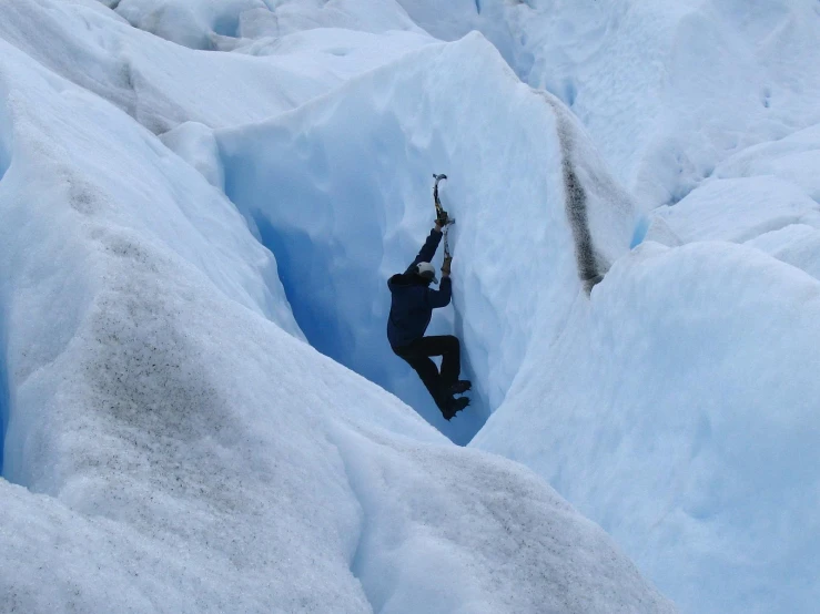 a person is climbing out of a  in the snow