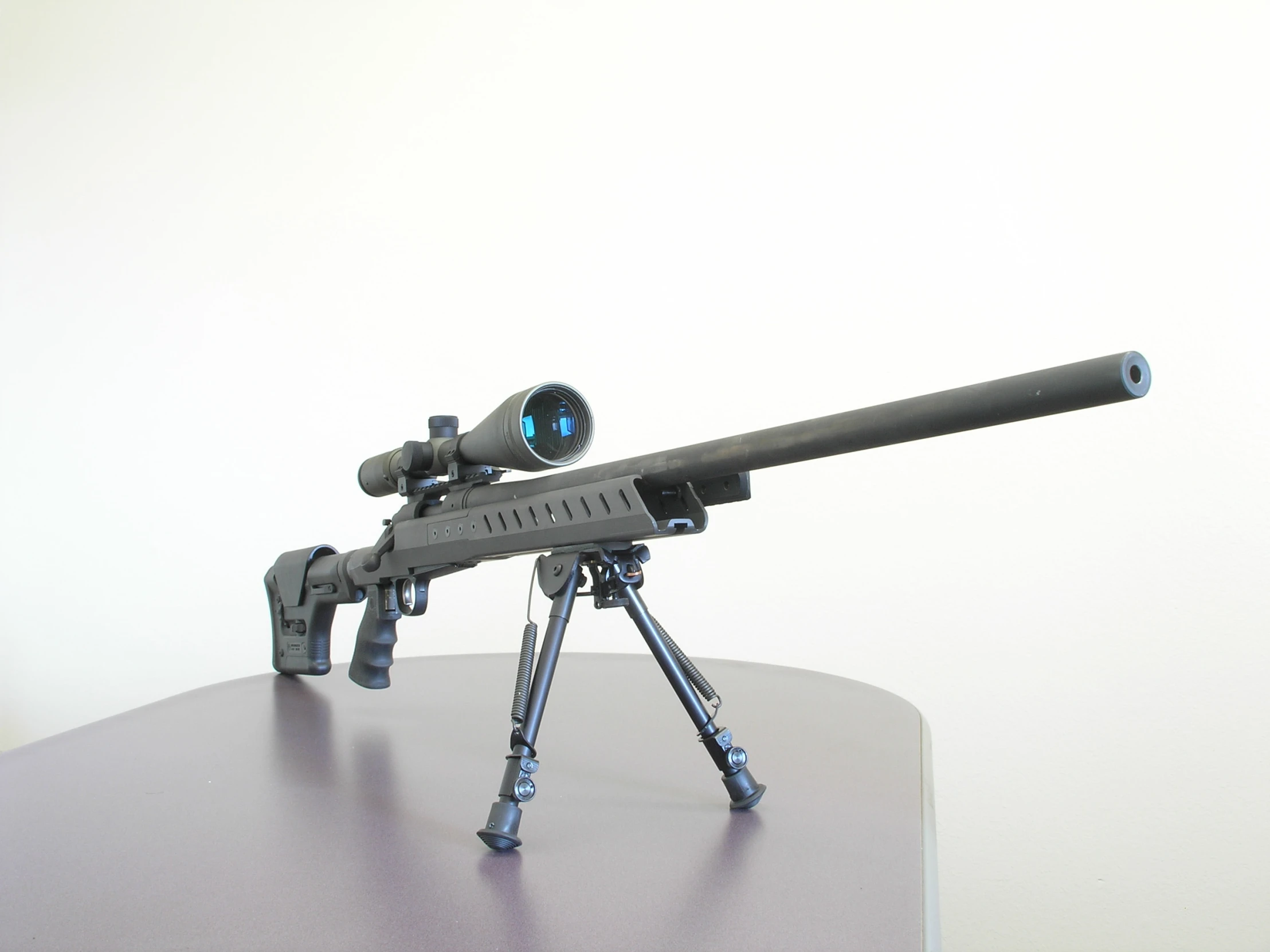 a rifle with an illuminated gun on a tripod