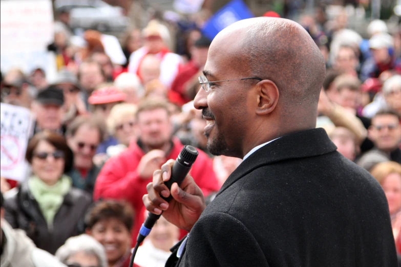 a man holds a microphone in front of an audience