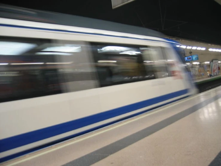 a train speeding down tracks in an indoor station