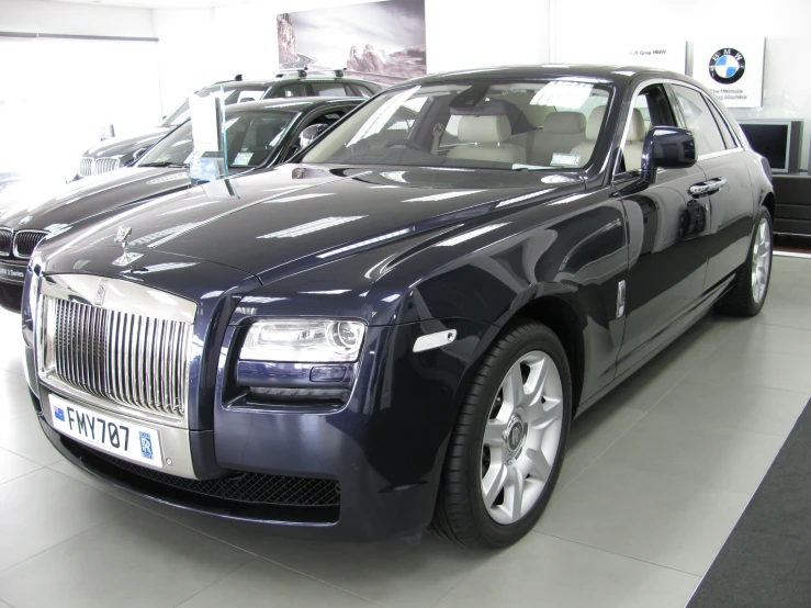 some rolls royces on display in a building