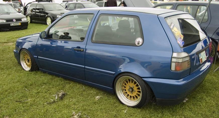 a blue car is parked in the grass