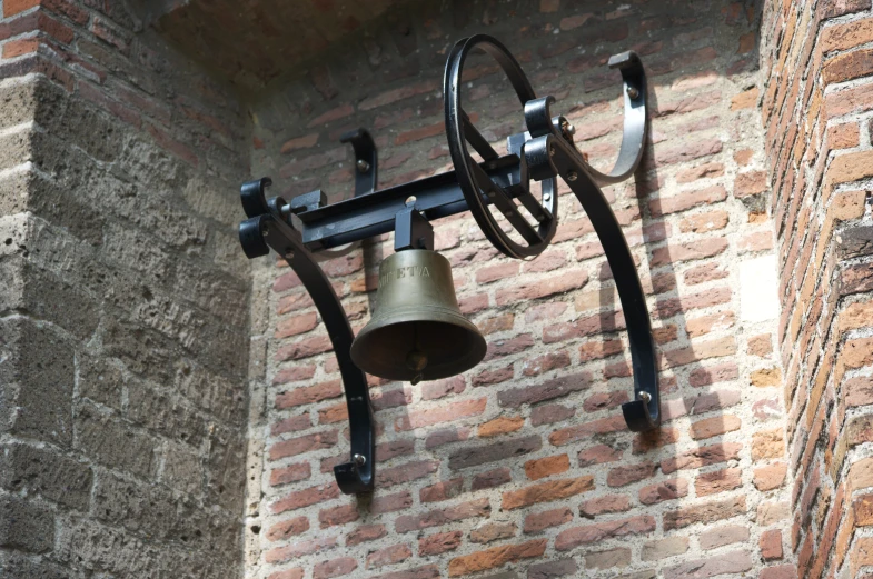 an old wall mounted bell and a large metal ring