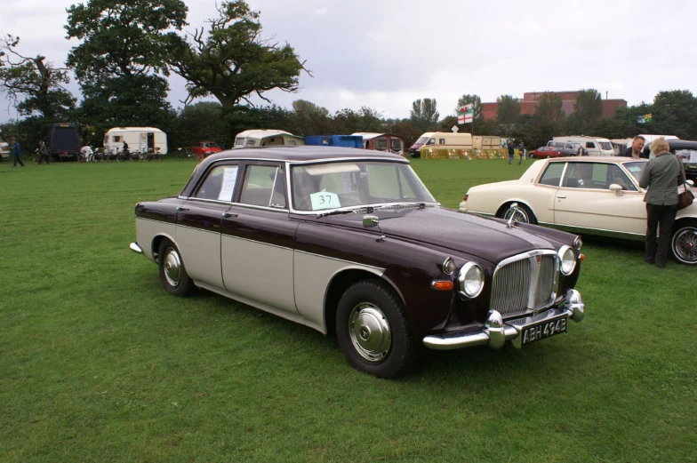 classic cars on display and a small one in the grass