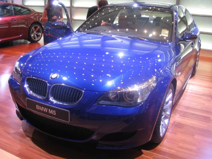 people are looking at a blue bmw