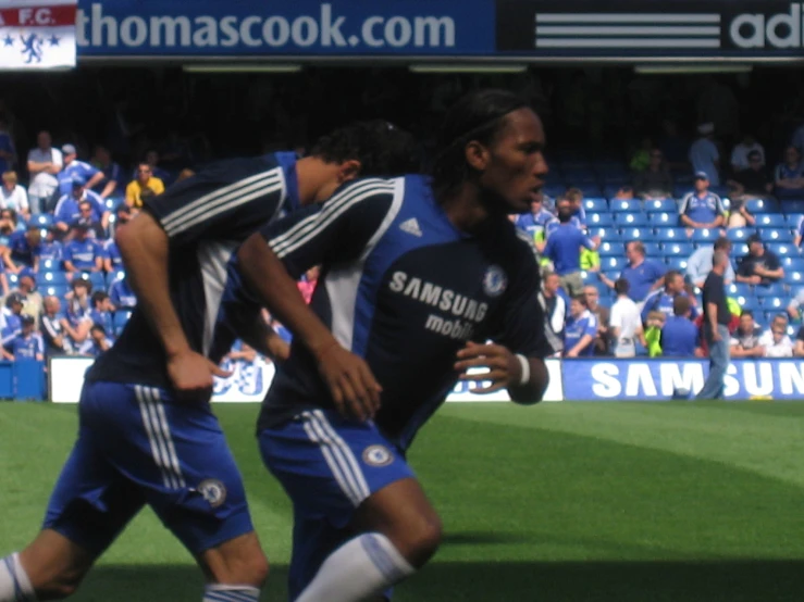 two men are going after the ball while onlookers watch