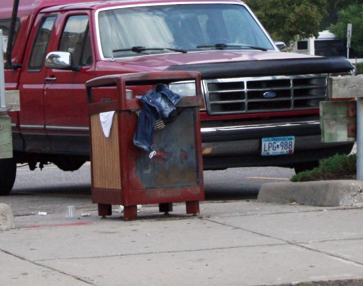 there is an old red truck that has been turned into a trash bin