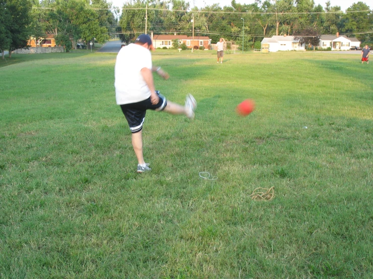 a person hitting a ball with their hand on the field