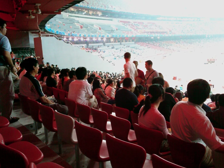 a crowd of people sitting in a stadium with seats