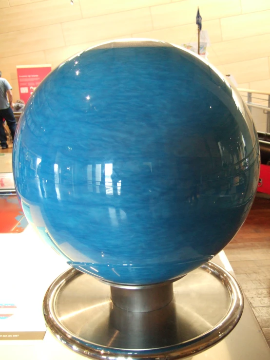 a big blue sphere with metallic trim in the middle