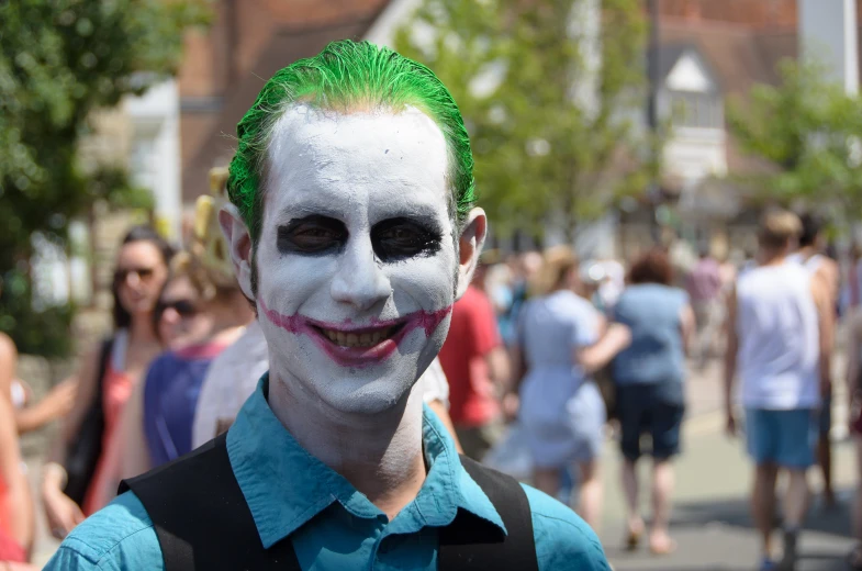 a person with painted makeup stands next to other people