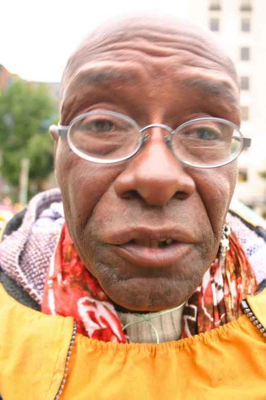 an older black man wearing glasses with an orange shirt