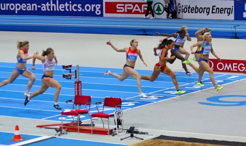 athletes in the middle of a run in a stadium