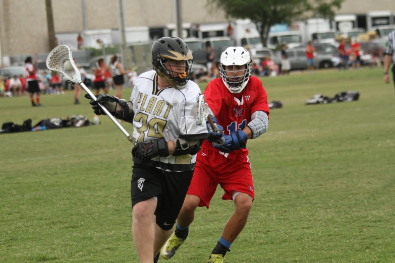 two men playing a game of lacrosse outside