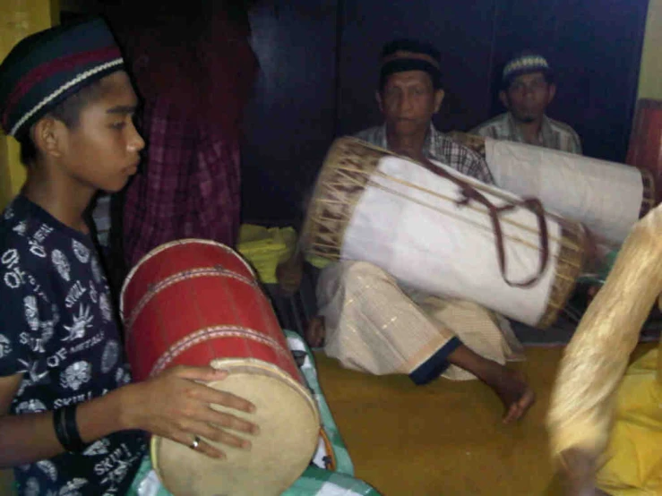 two people sitting on the ground while playing musical instruments