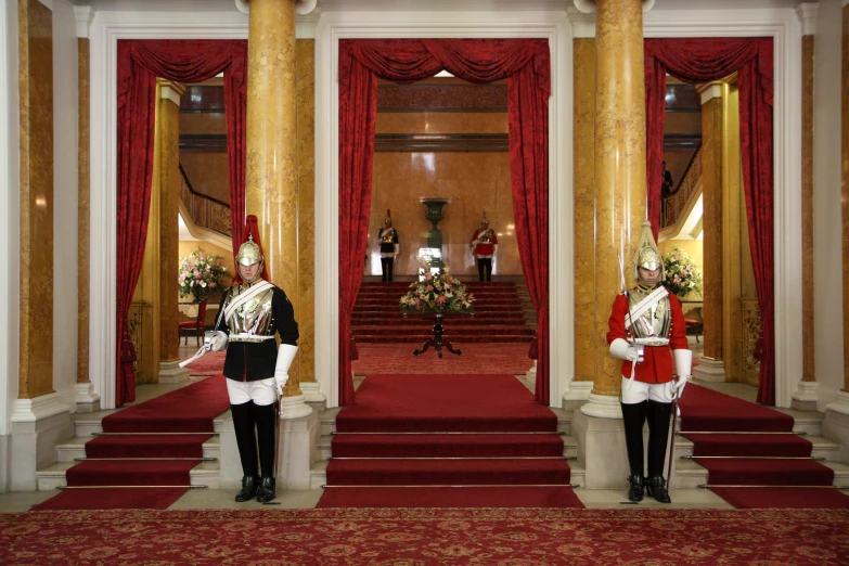 two men dressed in royal costume stand on steps