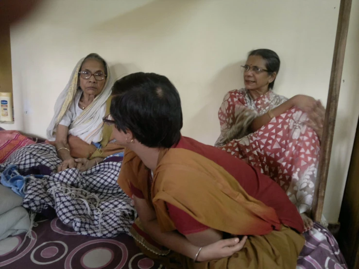 the three people are sitting on a bed