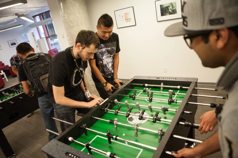 four men are working on a foo - do table