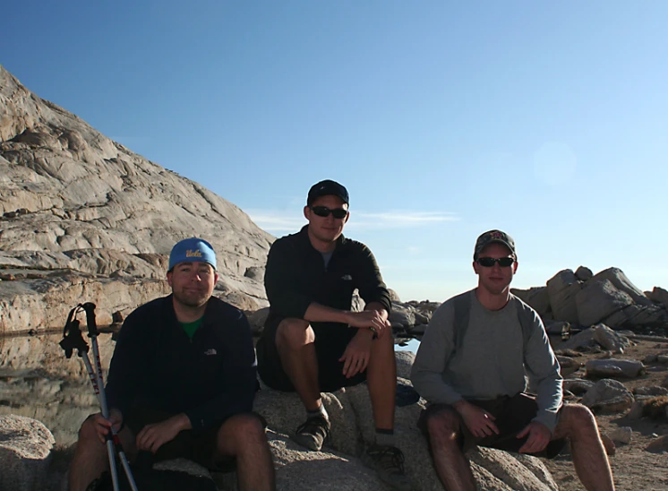 three people are sitting on rocks posing for a po