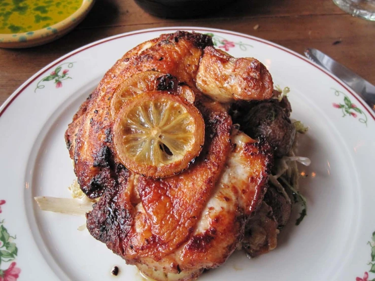 a dinner plate contains meat with lemons on it