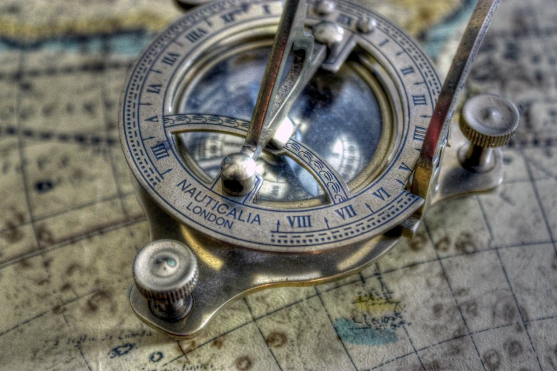 a closeup of a compass in focus on a world map