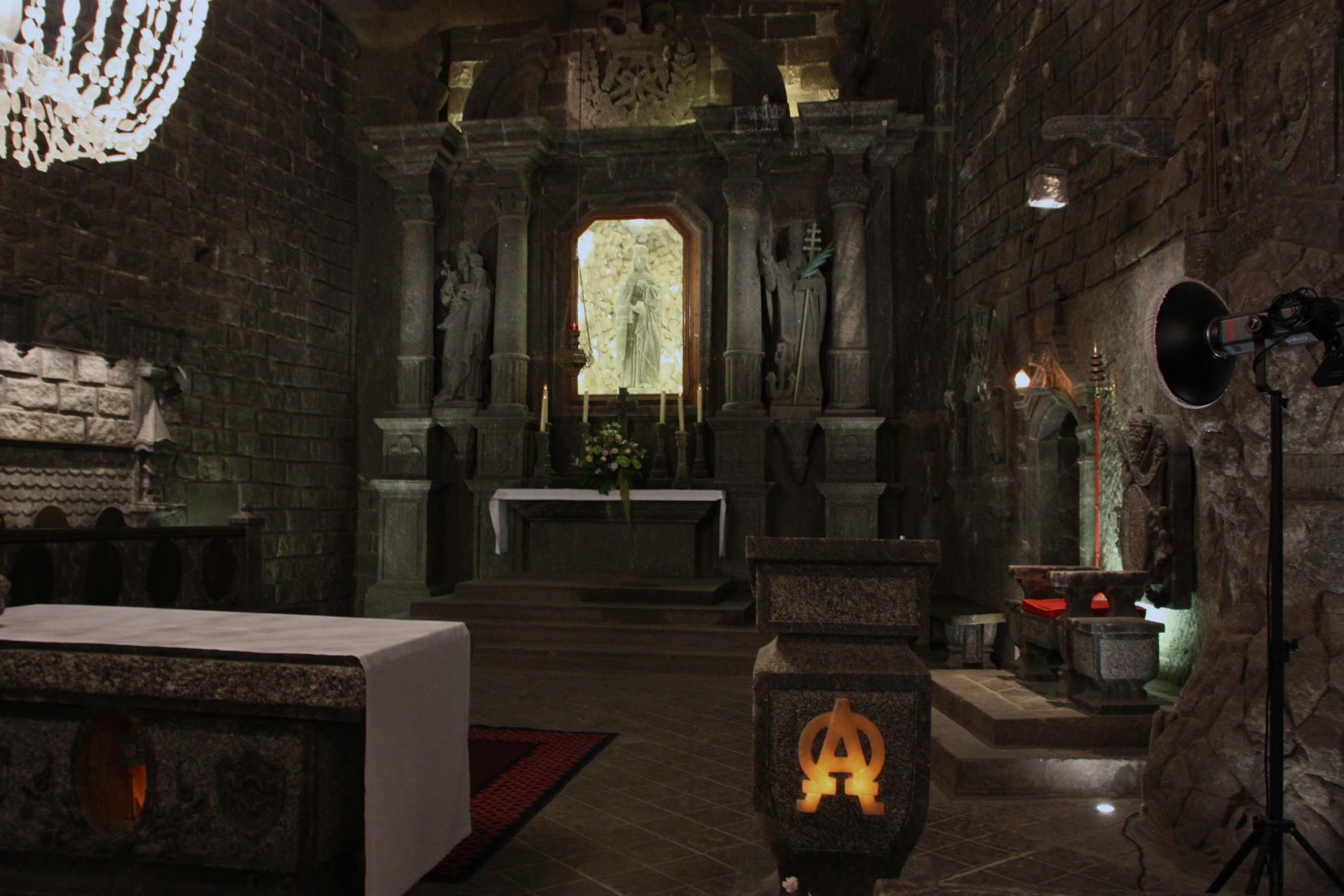 a dimly lit and dark stone church with decorations