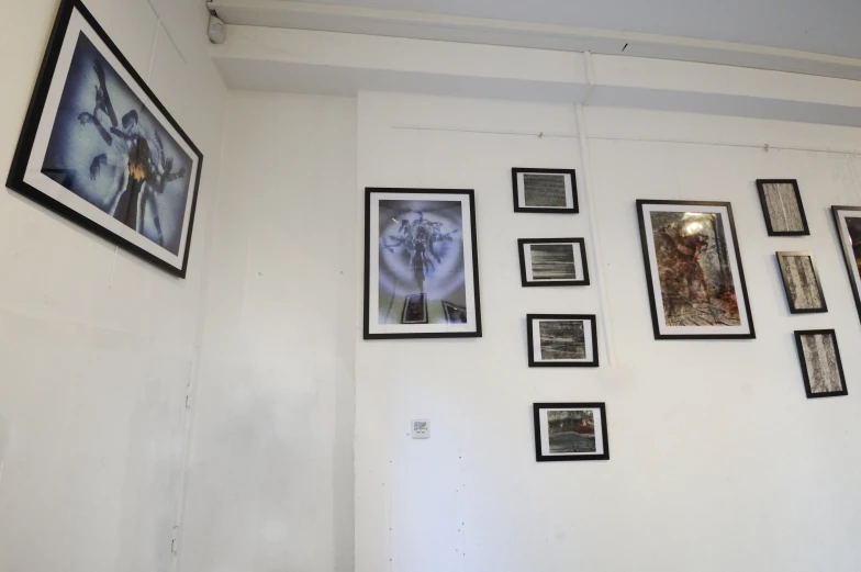 a wall with framed pos, picture frames and pographs