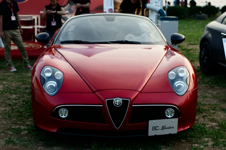 a red sports car parked near other automobiles