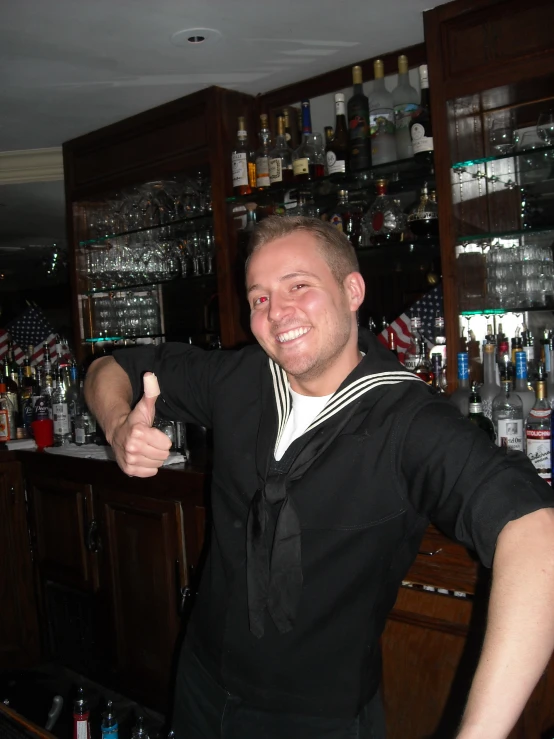 a bartender at a bar gives the thumbs up