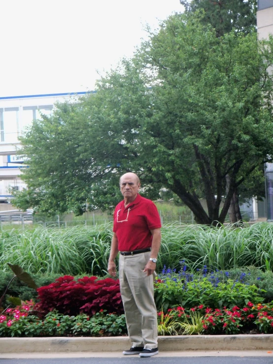 the man is standing in front of a green planter