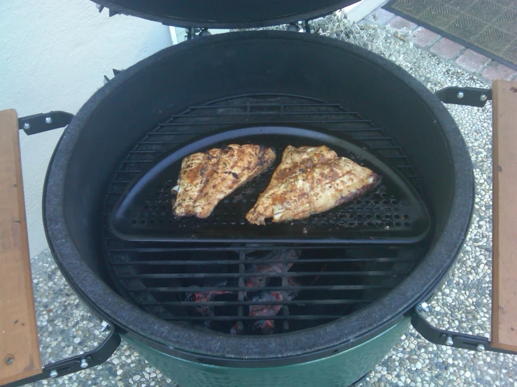 two pieces of meat cooking on a grill