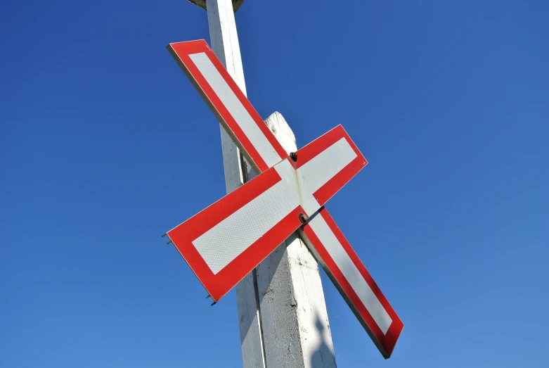 a tall cross mounted to the side of a building