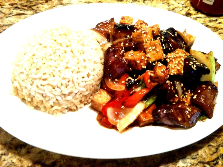 the plate contains vegetables and rice with sesame seed