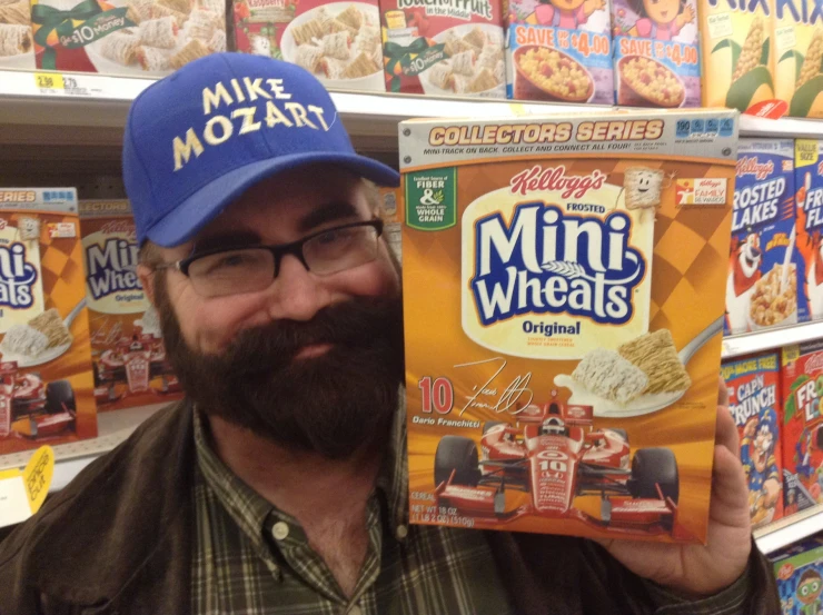 the man is wearing a hat while holding up his cereal